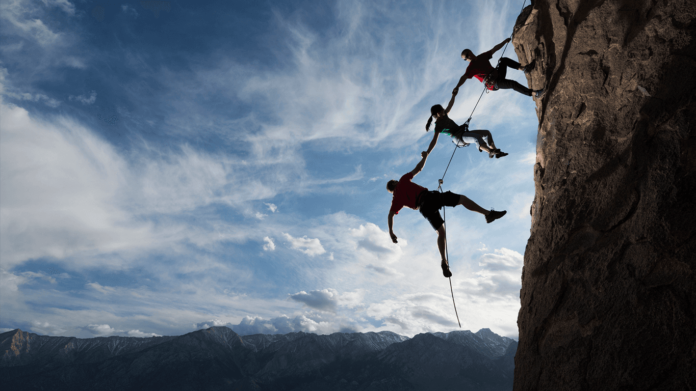 Three climbers supporting each other on a rock face, representing trust, assurance, and human oversight in high-stakes environments like responsible AI